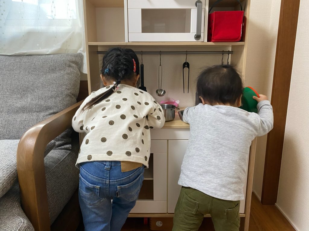 二人の子供がキッチンセットで遊んでいる